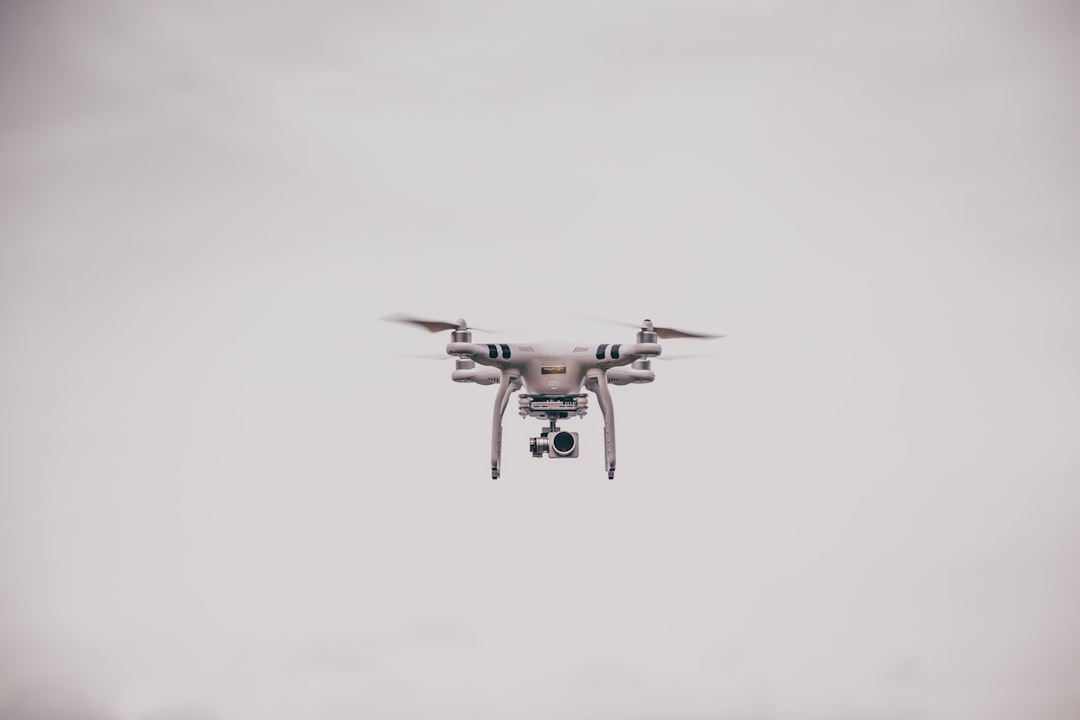 Commercial drone hovering in flight against an overcast sky