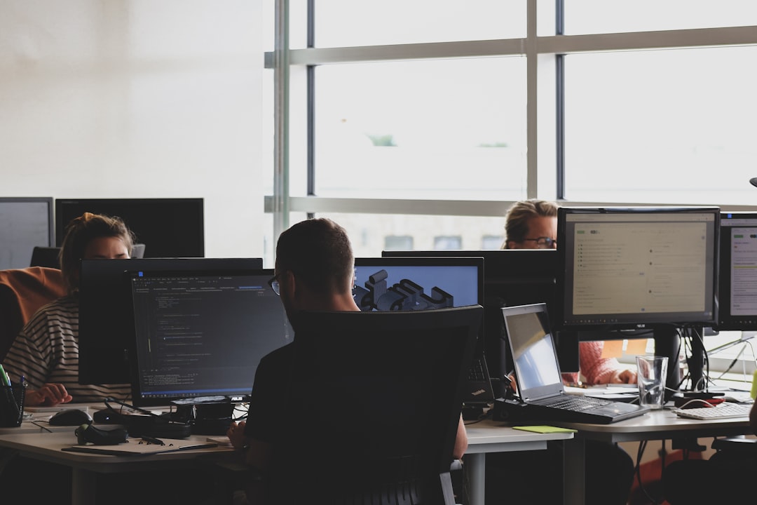 Commercial drone operations team comparing drone software companies and platform dashboards in an office