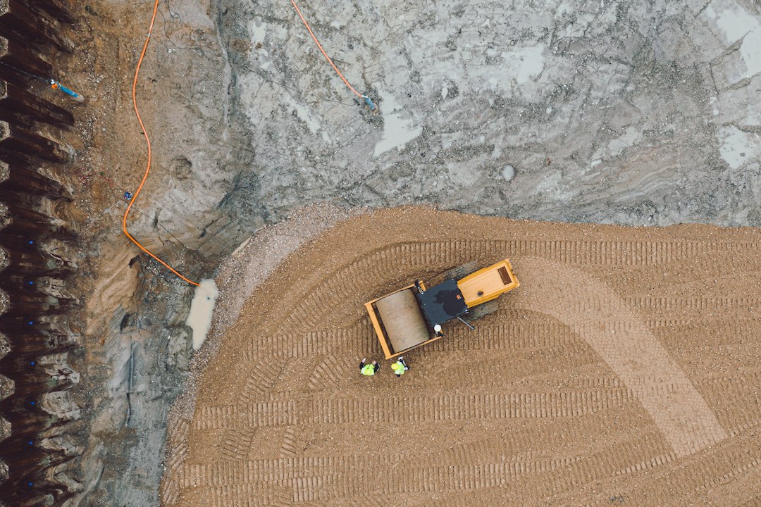 Top-down drone photo of a road roller compacting earthworks on a construction site, the kind of mapping work DroneDeploy pricing plans cover