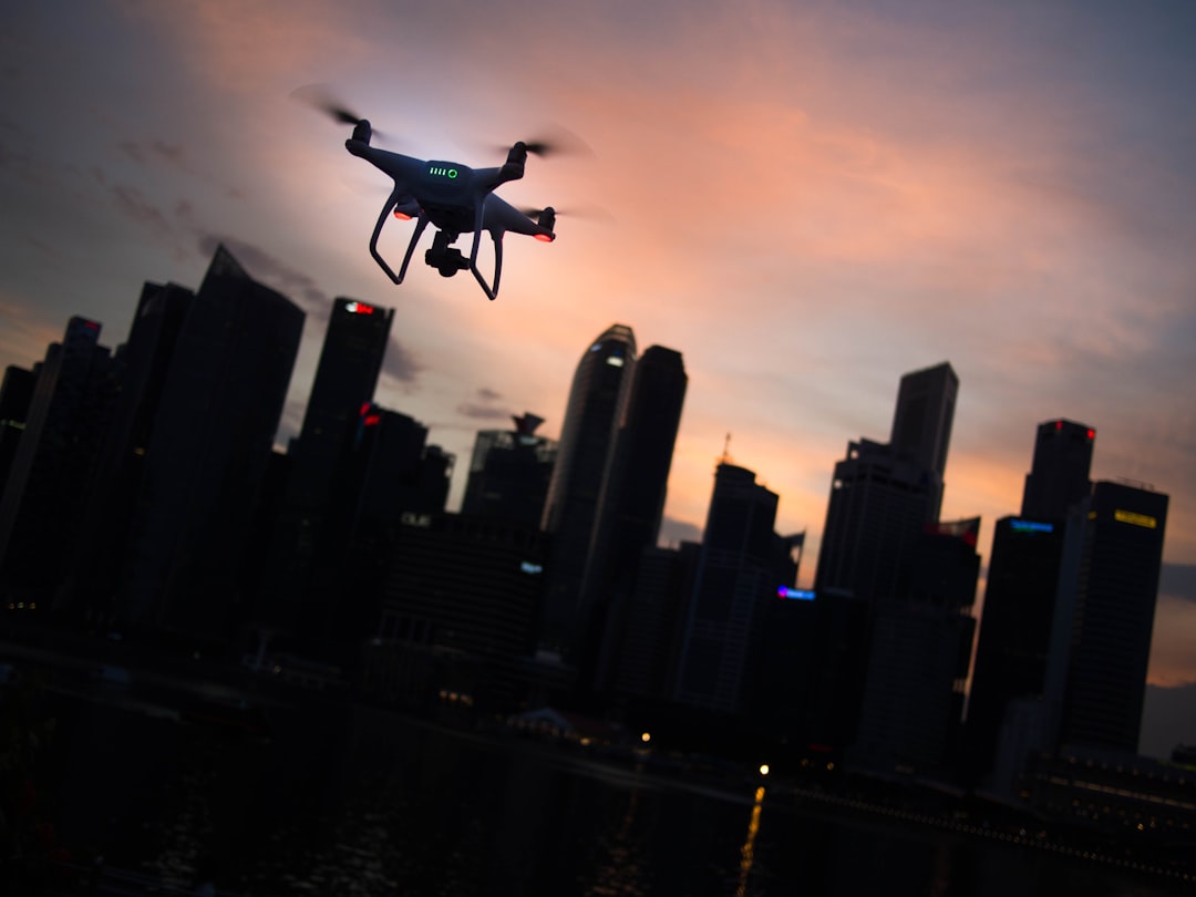 Drone hovering over a city skyline at dusk, the kind of urban airspace where drones for first responders operate