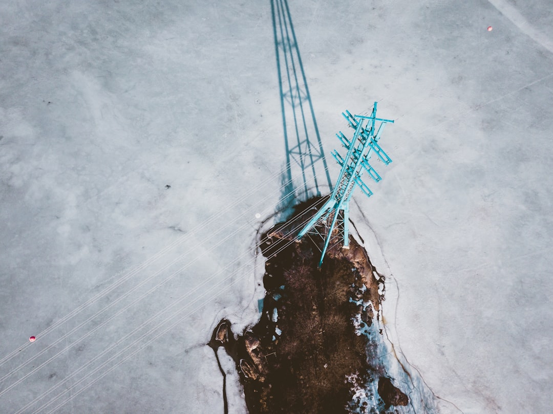 Aerial drone view of a high voltage transmission tower and conductors during a utility inspection flight