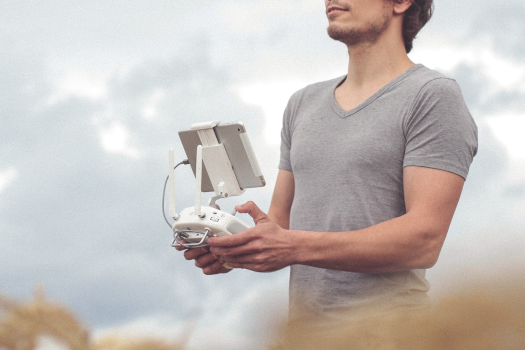 Commercial drone pilot holding a controller and reviewing Part 107 certification costs