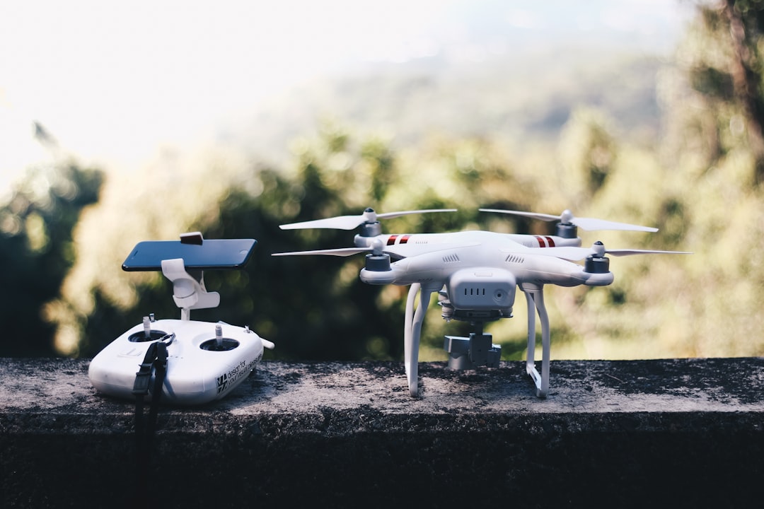 White quadcopter drone beside its remote controller, representing FAA drone registration renewal for commercial operators