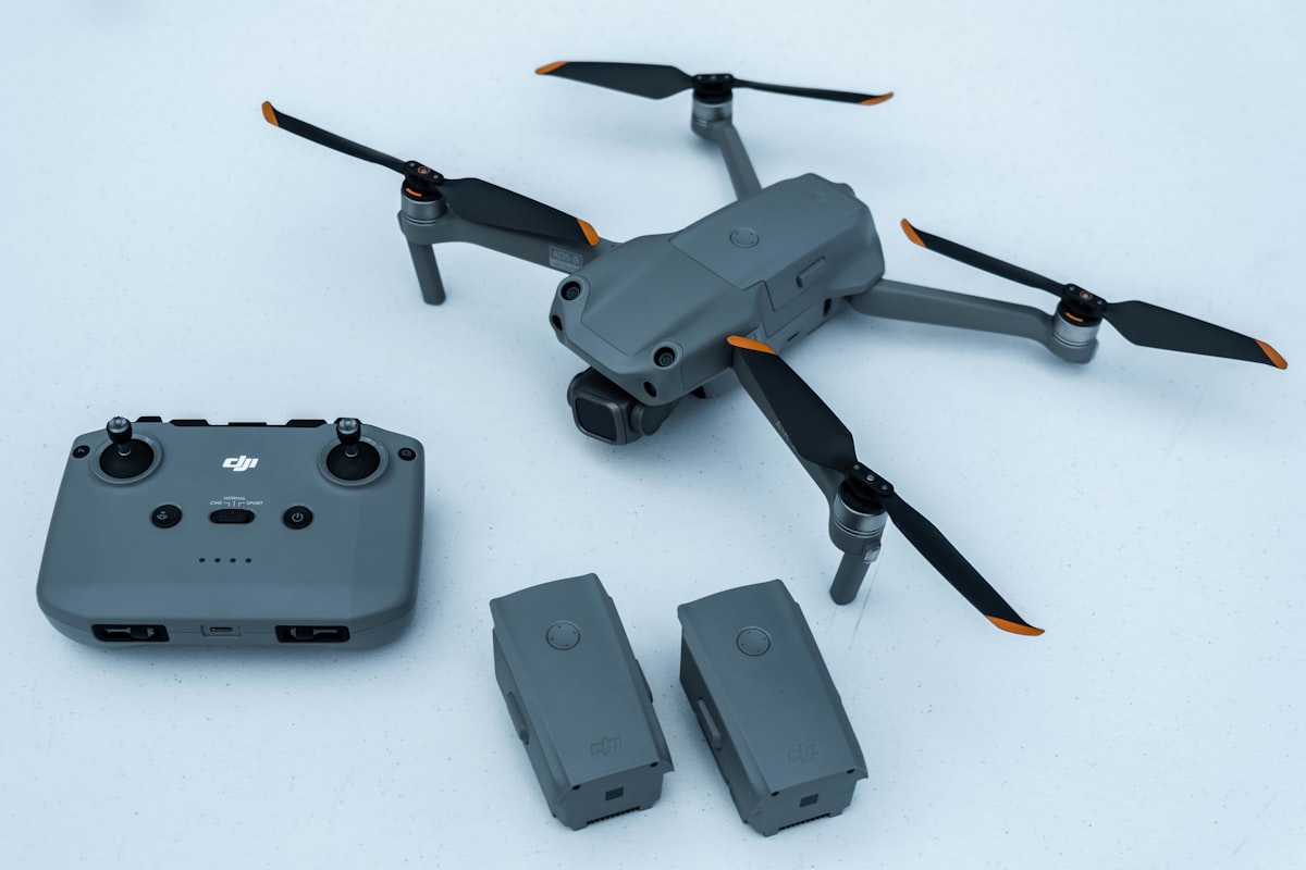 DJI drone with remote controller and spare batteries laid out on a white surface ready for FAA registration