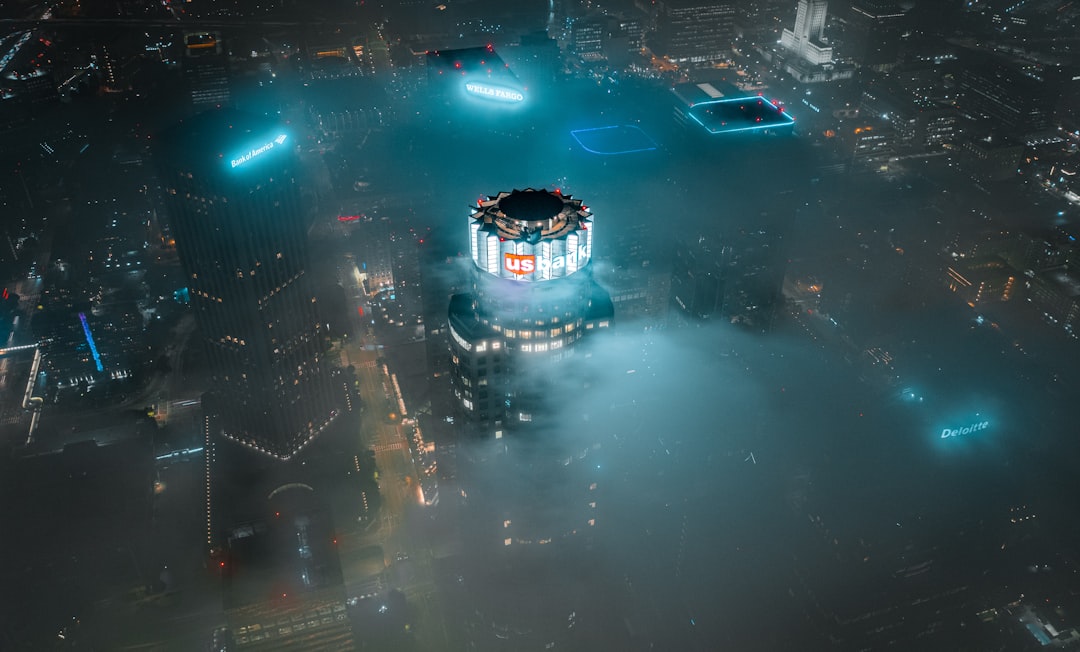 Police drone with red and blue strobe lights hovering over a residential neighborhood at night