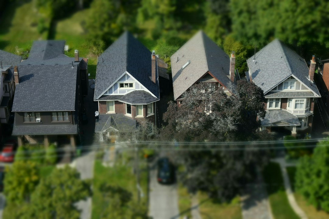 Aerial drone view of residential asphalt shingle roofs with chimneys and vents, the kind of roof a roof inspection report documents