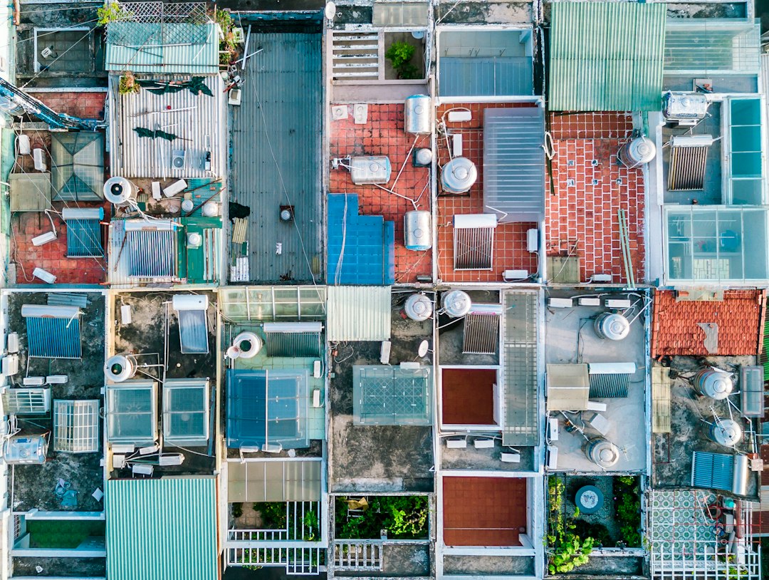 Top-down drone photo of flat rooftops with skylights, water tanks and HVAC units, the kind of roof a roof measurement tool has to handle