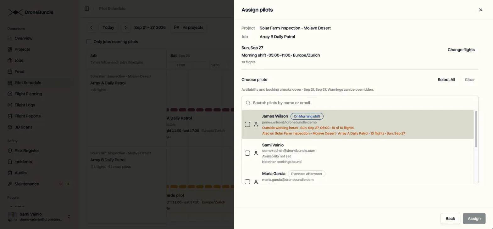 The Choose pilots step of the Assign pilots dialog, with each pilot’s planned shift, working hours check, and other bookings listed